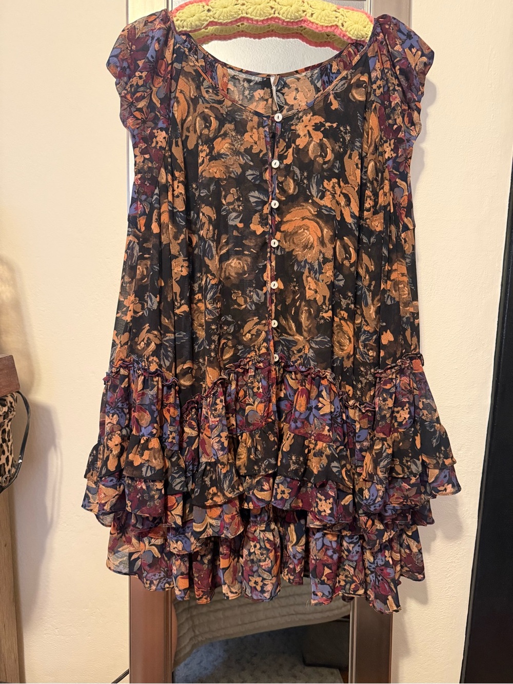 Free People sheer floral button-frontdress. Subtle high- low and ruffle detail.